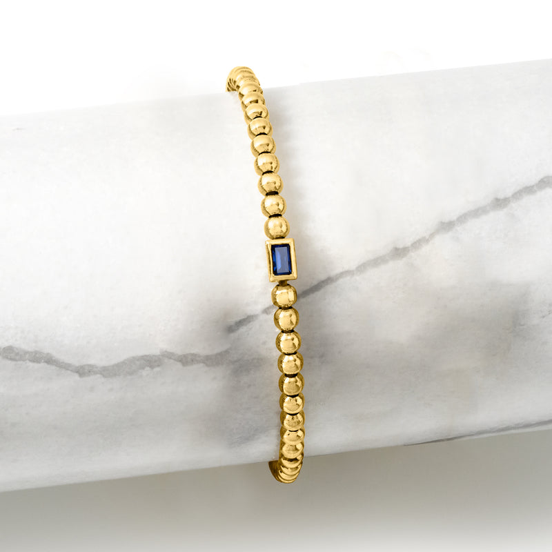 Gold bead stretch bracelet with rectangular blue gemstone detail