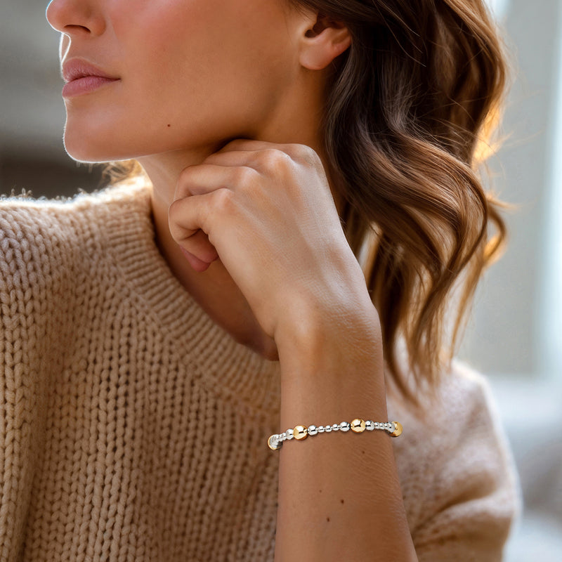 Sterling silver bead bracelet with small gold over silver round beads on wrist