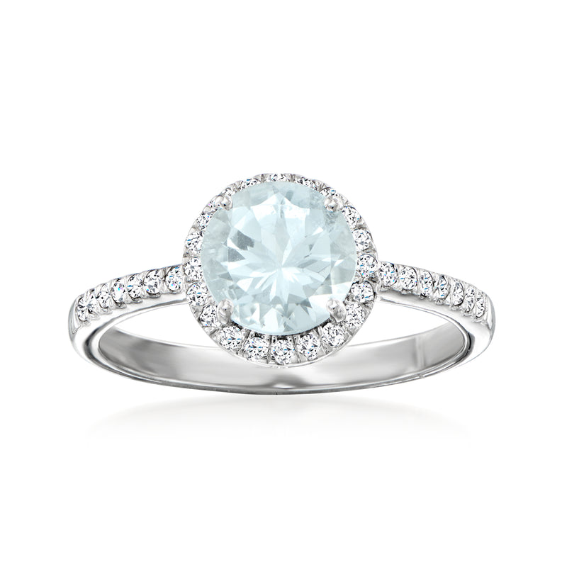 Platinum aquamarine ring with round center stone, diamond halo, and pave band