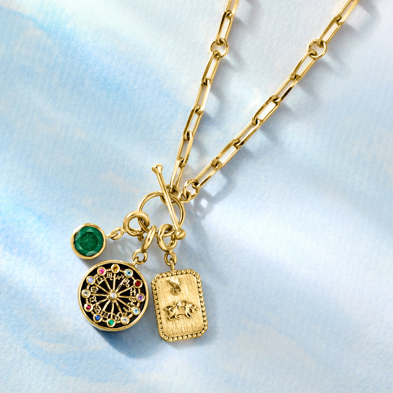 Gold-tone charm on chain with green round stone and star detail