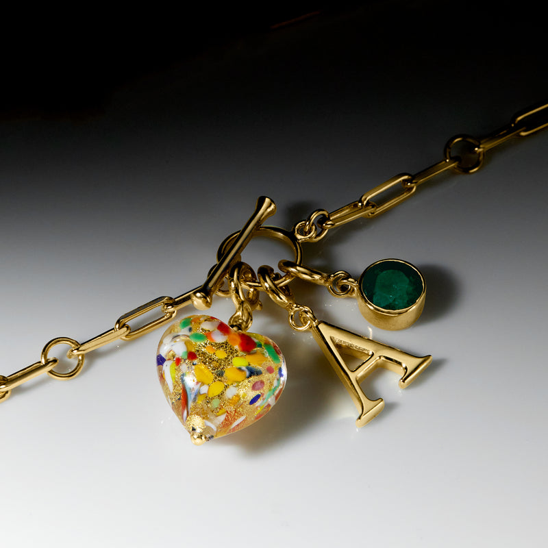 Gold-tone charm necklace with colorful heart charm and green round stone