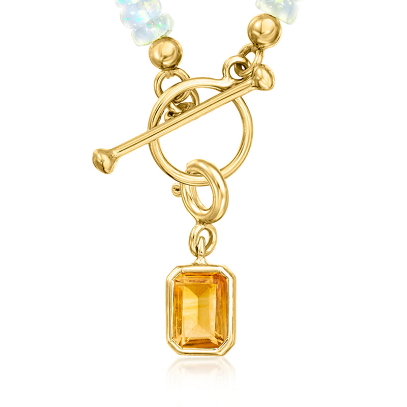Gold-toned pendant with emerald-cut amber birthstone and ring-link bail
