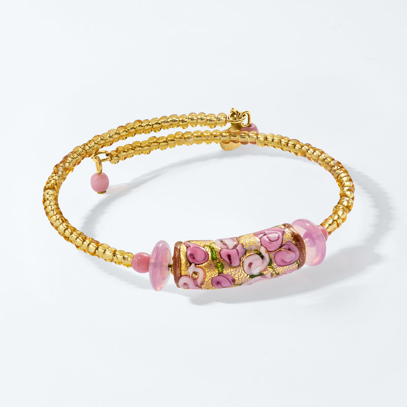 Gold-tone wrap bracelet with rectangular pink floral center bead and pink glass spacers
