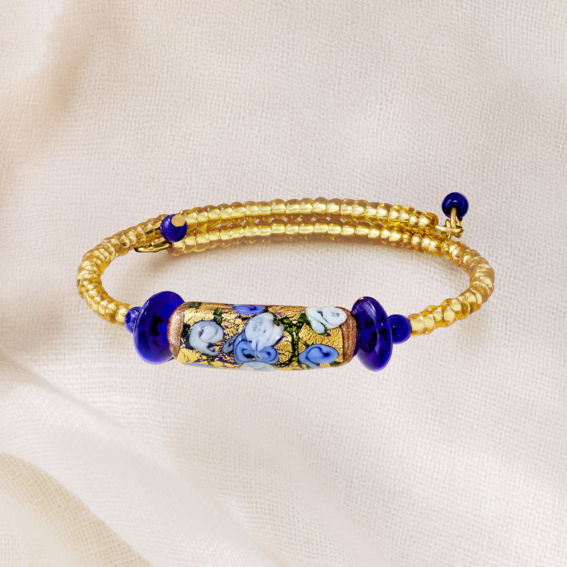 Gold bead wrap bracelet with oval blue floral glass centerpiece and dark blue beads