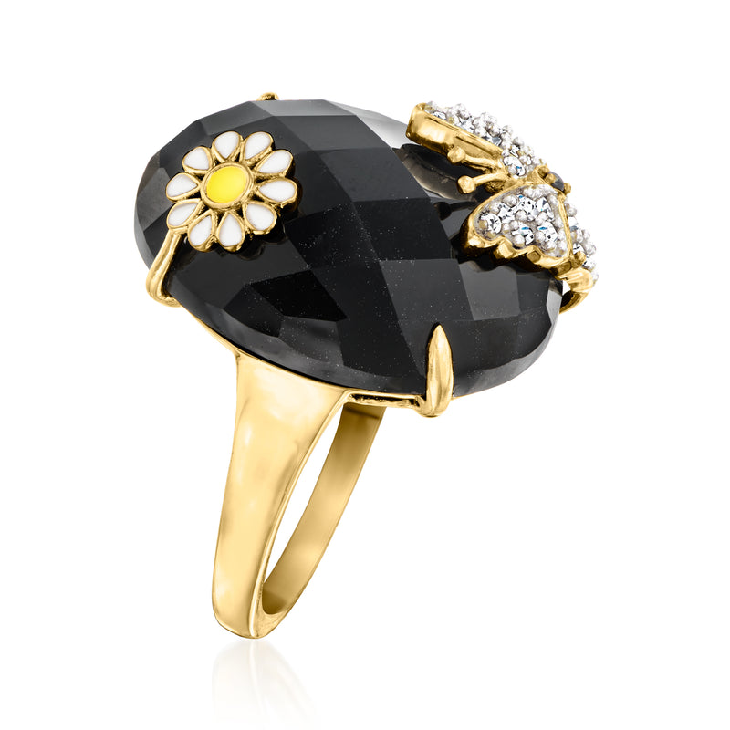 Gold-tone ring with black faceted oval stone, yellow flower top, white crystal bow detail