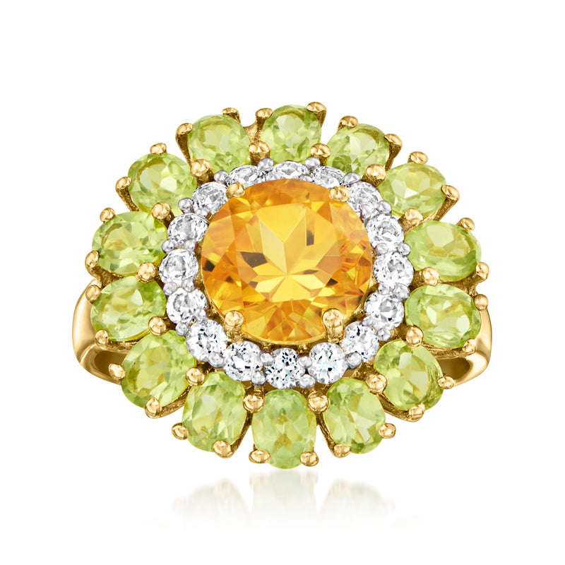 Gold-tone ring with orange round citrine center, green peridot petals, white topaz halo.
