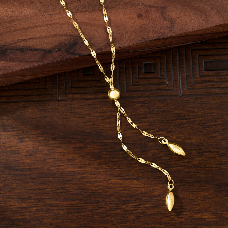 Long yellow gold lariat necklace with layered chain and oval drop charms