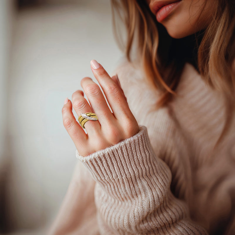 Snake ring worn on finger: yellow gold band, platinum top, and small diamond setting