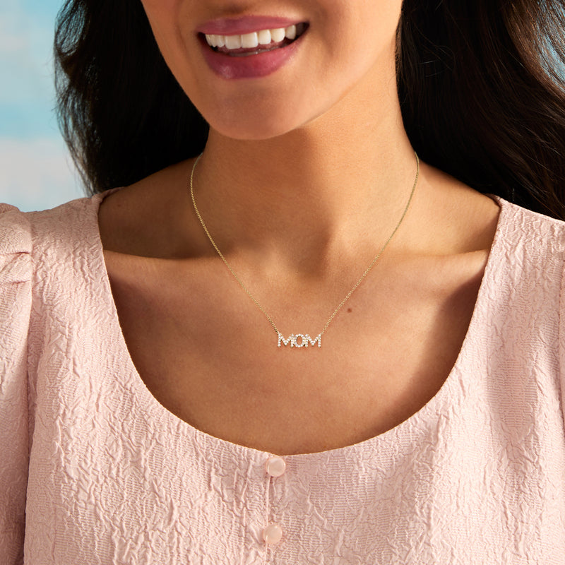Gold over sterling 'MOM' pendant necklace resting at the collarbone