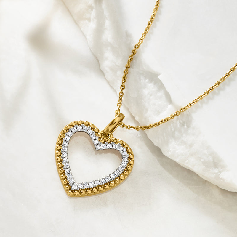 Gold heart pendant on chain with diamond-like pave border and raised frame