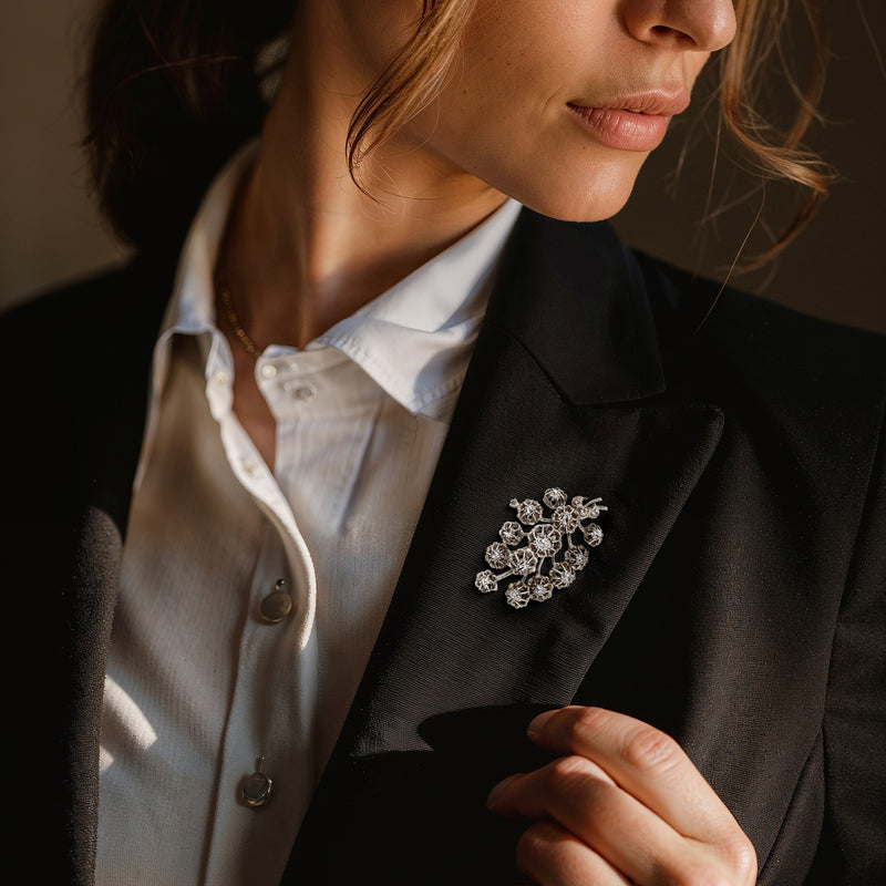 Diamond flower pin on a suit lapel with clustered round stones