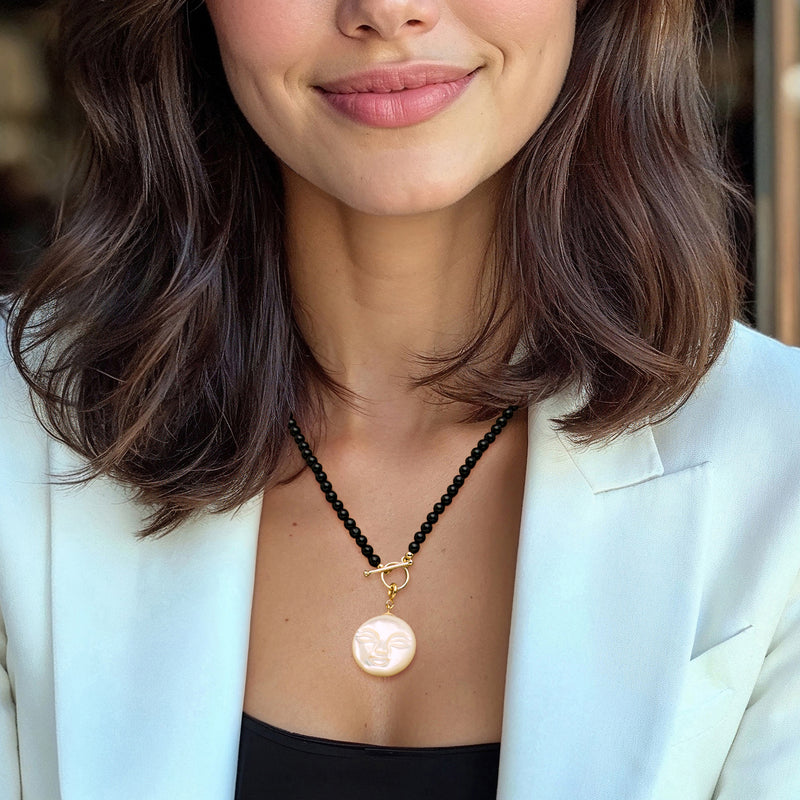 Moon charm necklace on black beaded chain with white mother-of-pearl face pendant