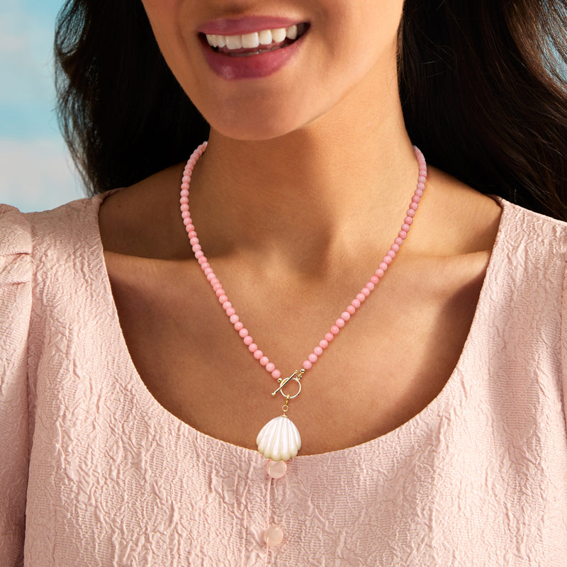 Seashell charm on pink bead necklace with gold clasp and white shell