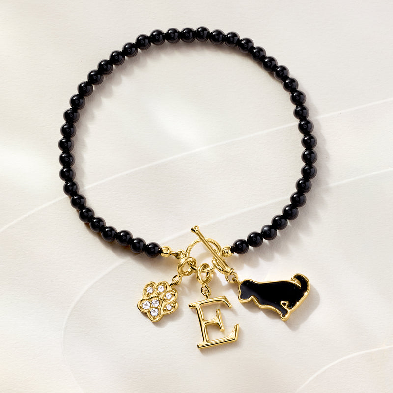 Black bead bracelet with gold-tone dog charm, letter E charm, and rhinestone paw charm