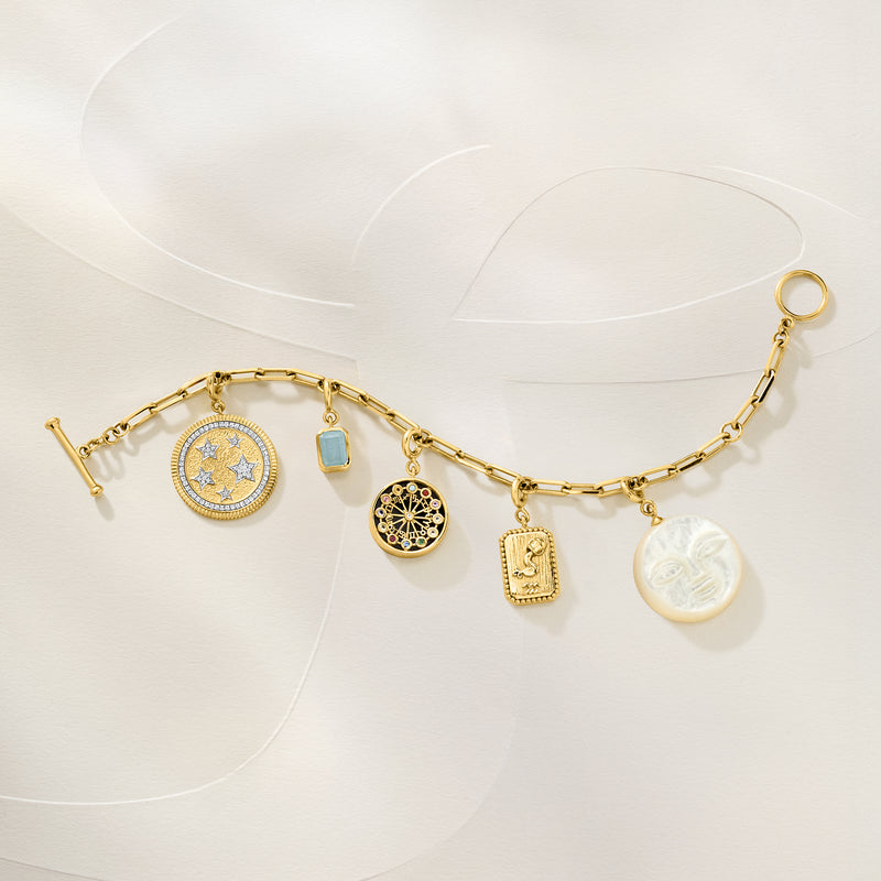 Gold-tone charm necklace with several dangling symbols, including round multicolor zodiac charm