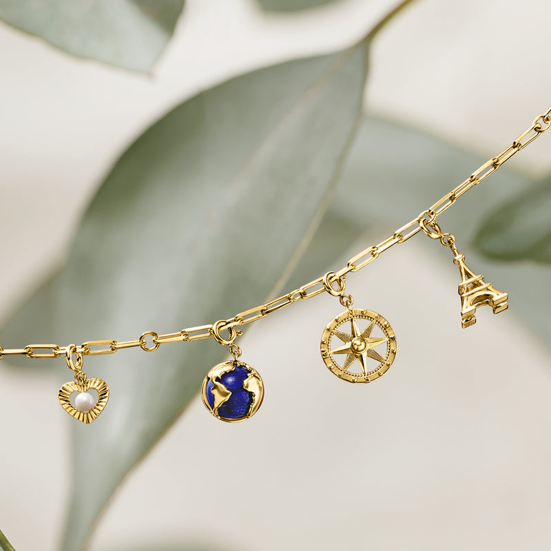 Gold chain with blue globe charm pendant, compass charm, and small accents