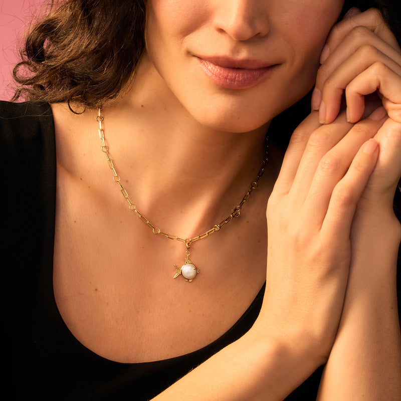 Gold pearl necklace featuring a fish charm with coin pearl pendant at center