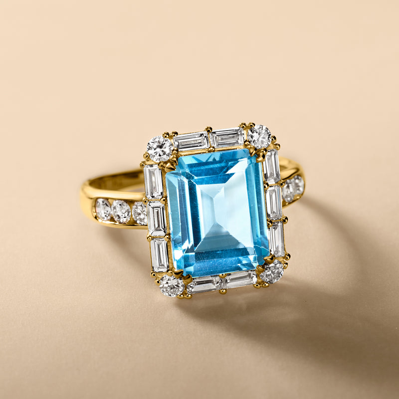 14kt yellow gold ring with blue topaz center and baguette diamond halo