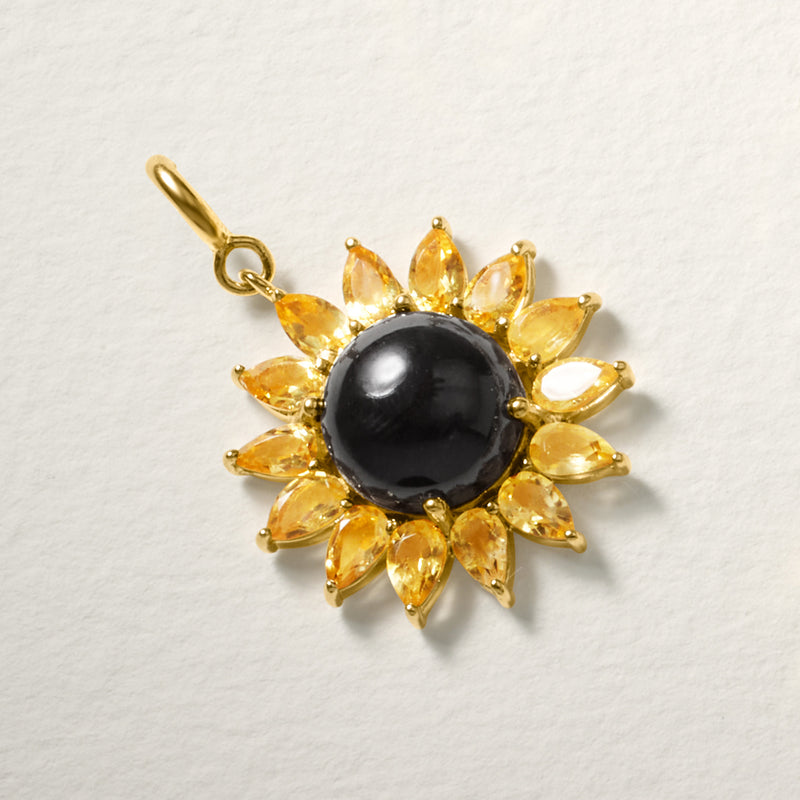 Gold-tone flower charm with glossy black round center and yellow petal accents, hanging