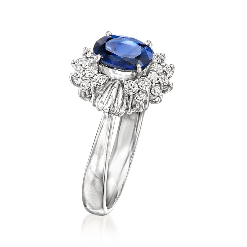 Platinum ring with blue oval sapphire and clustered diamond detail
