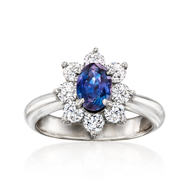 Platinum ring with oval blue-violet gemstone and diamond halo with side diamond clusters