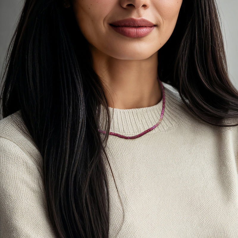 Multicolored ruby bead necklace worn close to the neck