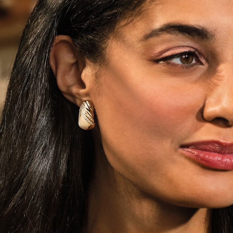 Vintage curved diamond earring in 14kt yellow gold on a model's ear