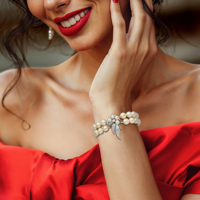 Pearl bracelet with diamond ribbon bow charm on wrist, 14kt white gold