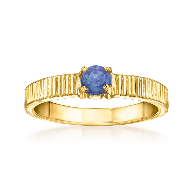 Gold ridged ring with blue sapphire-style center stone and scalloped bezel