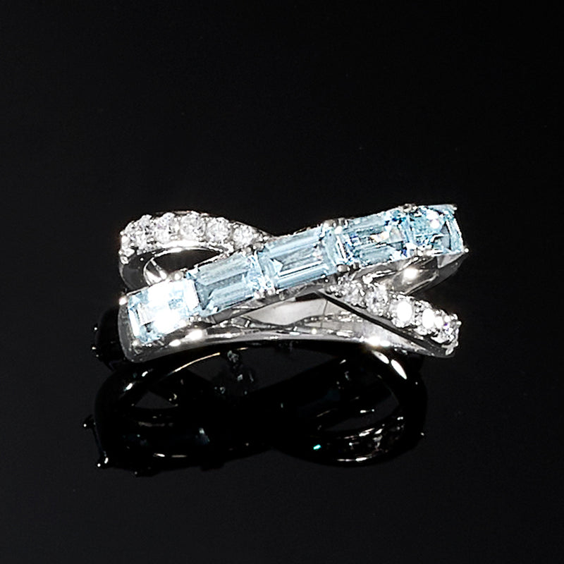 Sterling silver crisscross ring featuring two icy blue stones and sparkling diamond bands