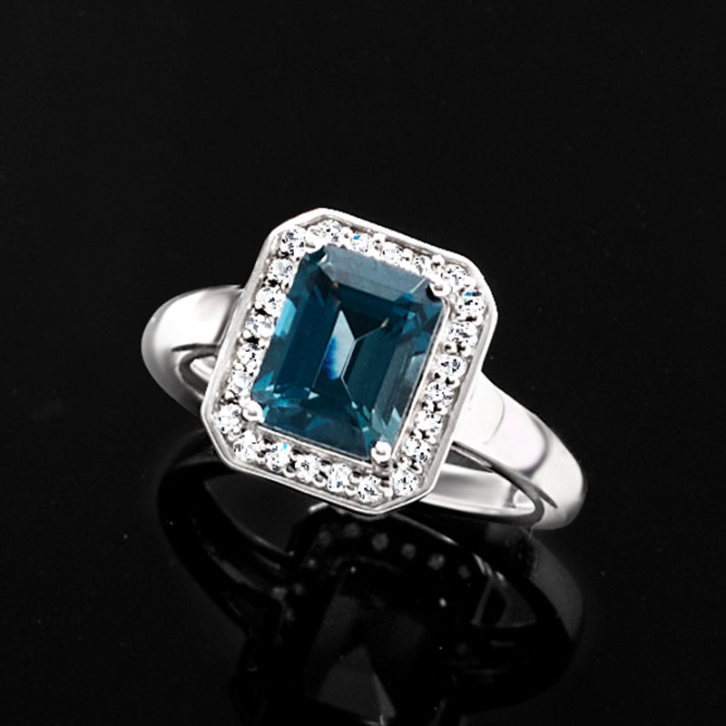 Sterling silver ring featuring square blue topaz and diamond halo detail
