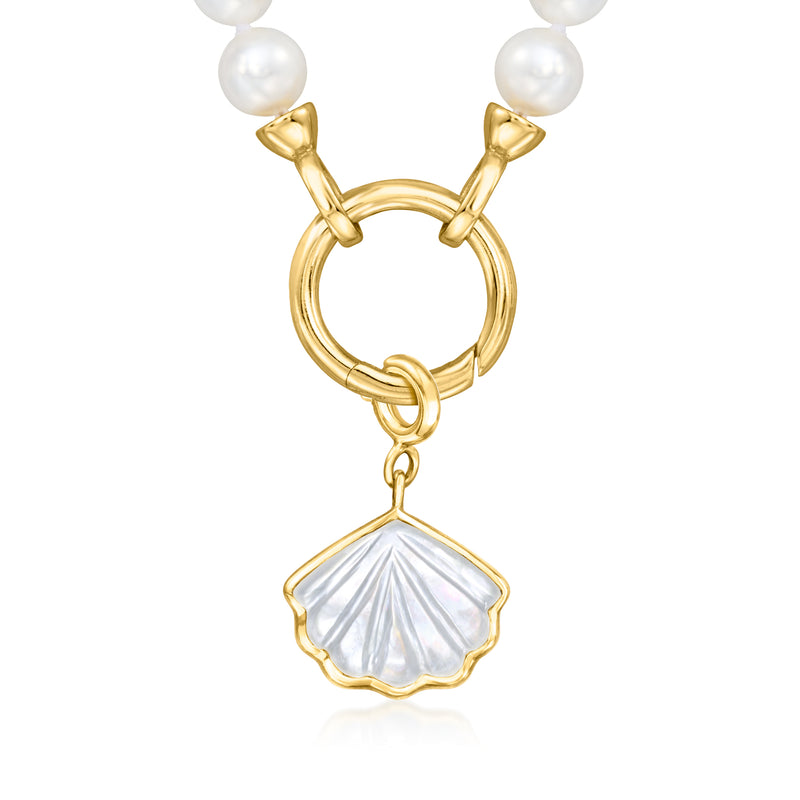 Mother-of-pearl shell charm on gold loops, shown between white pearl strands