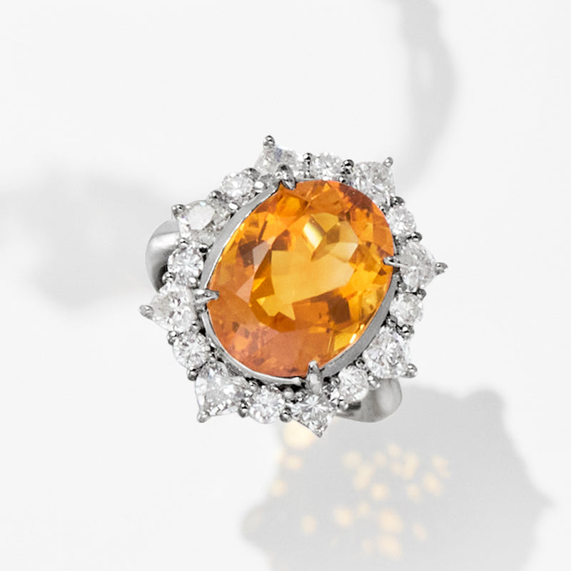 Platinum cocktail ring with oval citrine gemstone and surrounding round diamonds
