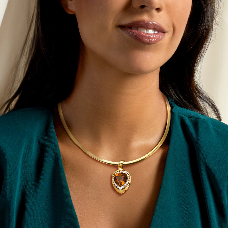 Gold necklace pendant with oval amber citrine center and diamond halo on wearer