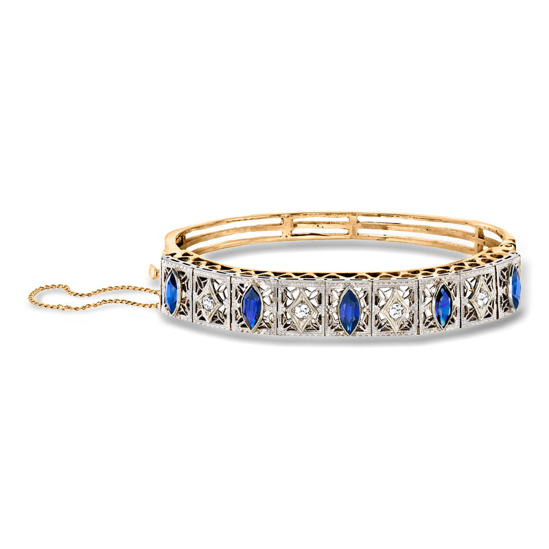 Filigree bangle bracelet with blue stones, diamond-like accents, gold and platinum