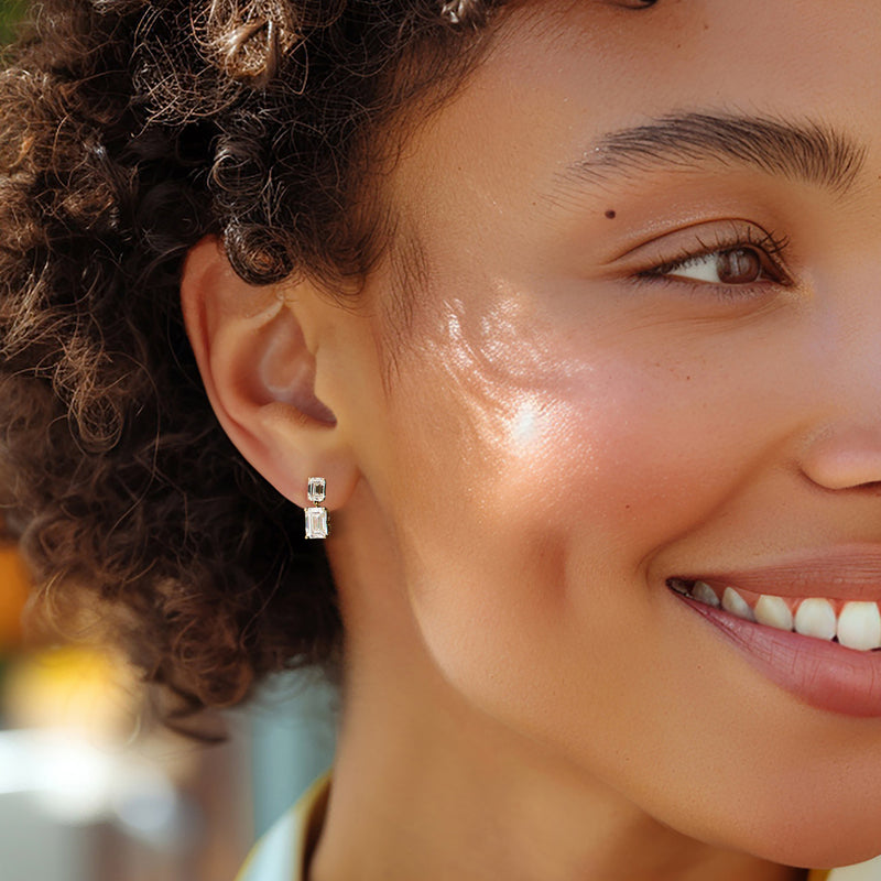 Close-up of yellow gold drop earrings with emerald-cut lab-grown diamonds