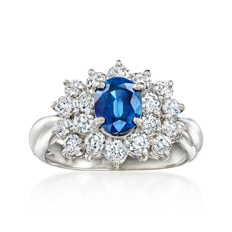 Platinum ring with oval blue sapphire center and round diamond halo cluster