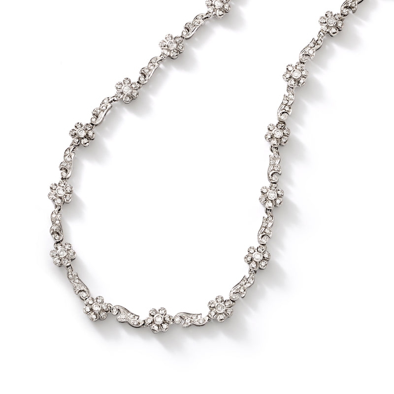 Diamond flower necklace detail with scalloped round stone clusters in white gold