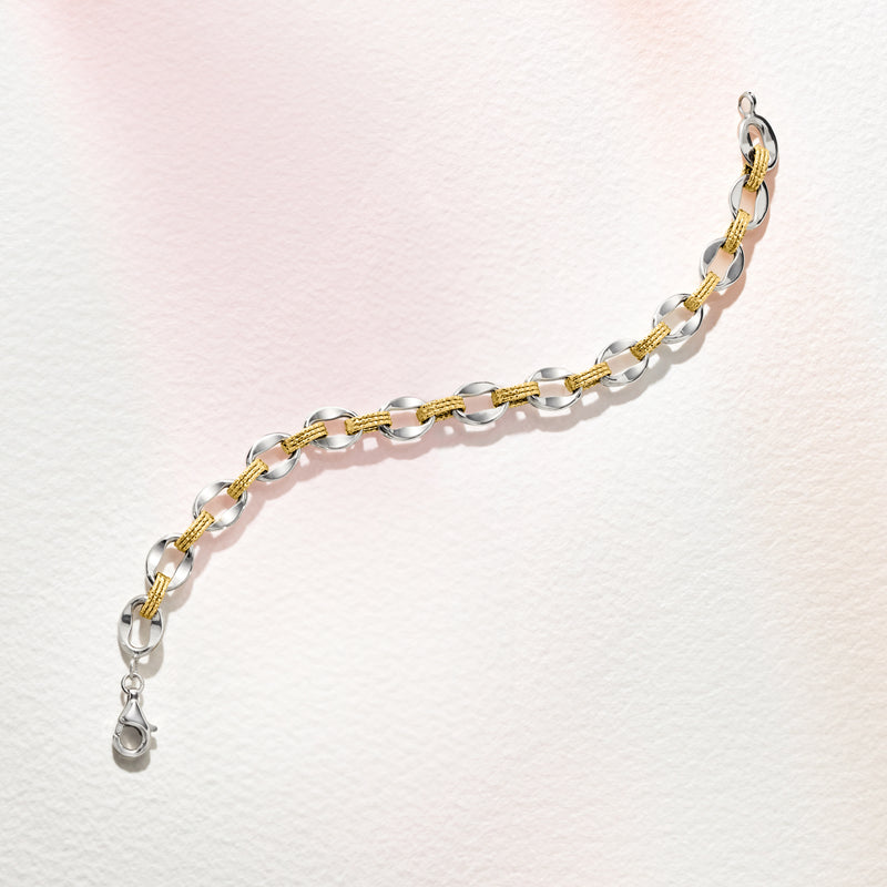 Oval-link bracelet with alternating gold accents and silver links; lobster clasp end.