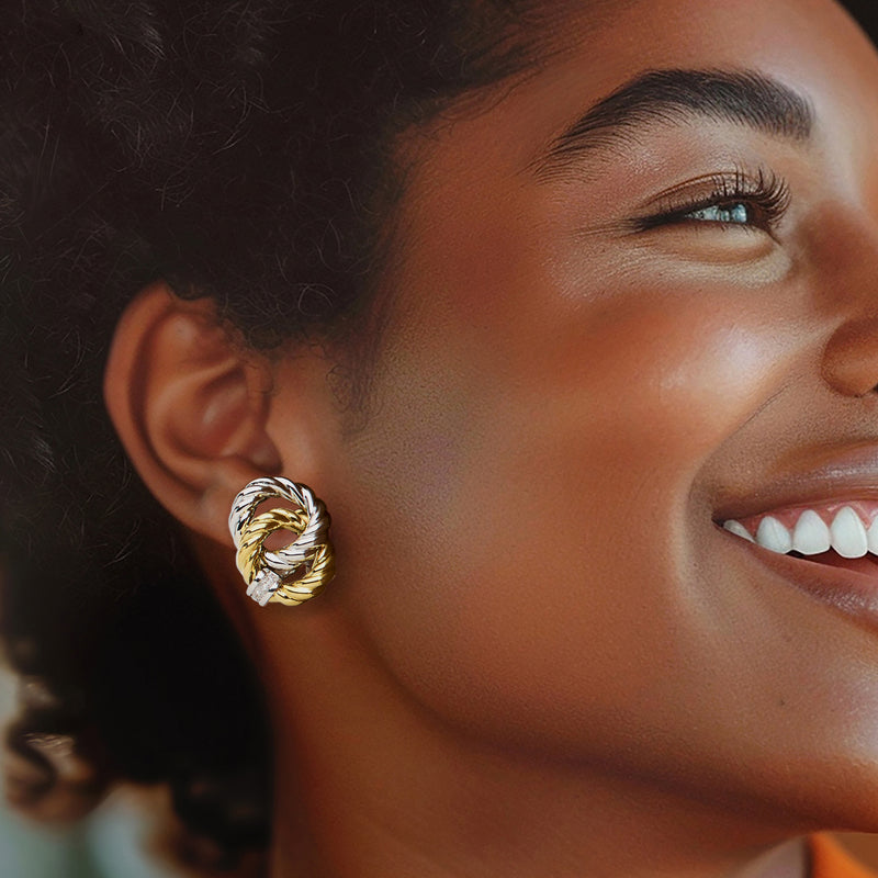 Two-tone interlocking circle clip earrings with diamond accent, worn on ear.