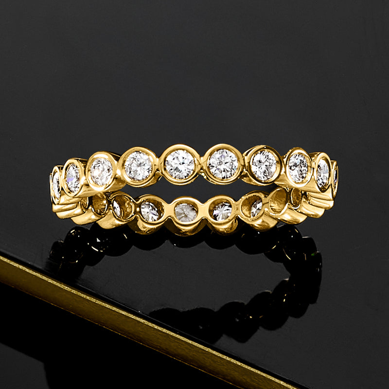 Gold eternity band with bezel-set round diamonds, front view