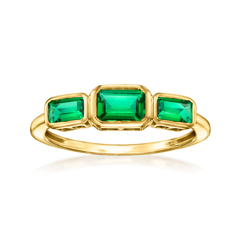 Gold three-stone ring with emerald-cut green gemstones