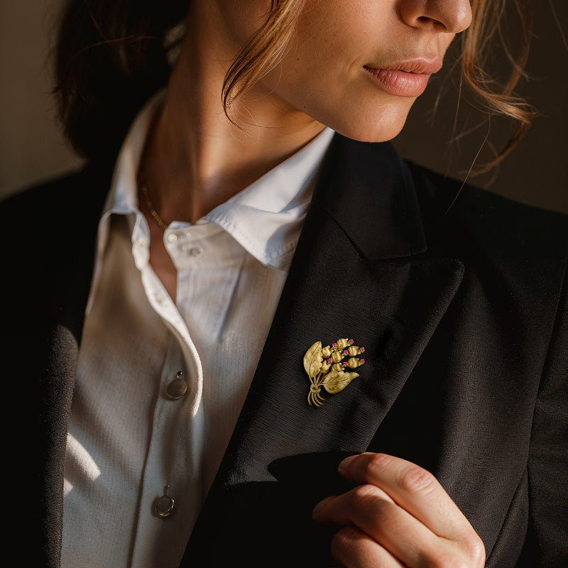 Vintage yellow gold flower bouquet lapel pin with ruby pink stones, worn on jacket
