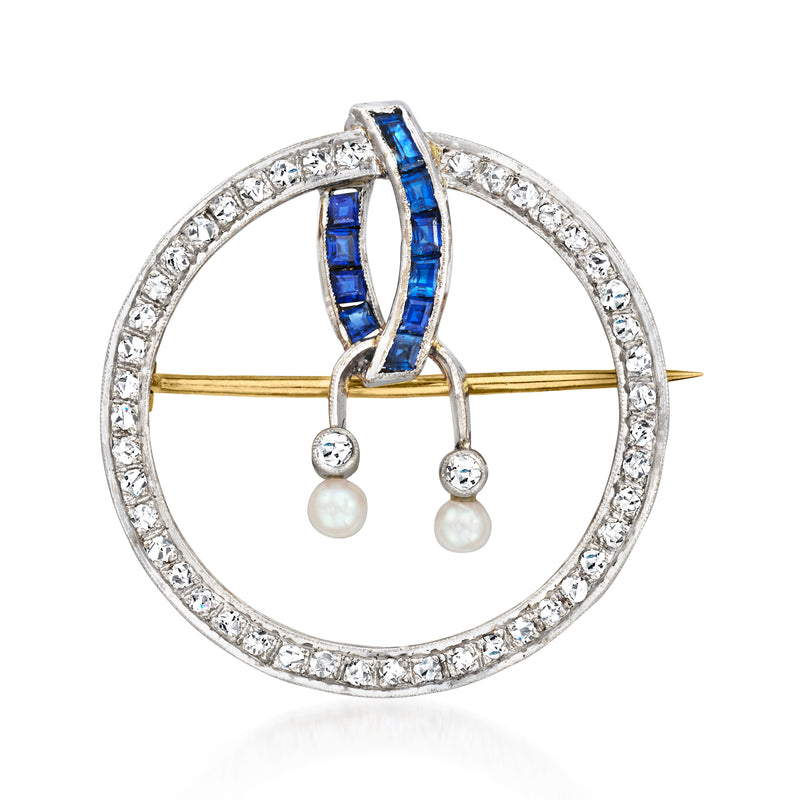 Vintage circular pin with blue sapphire center, diamond halo, and two pearl drops.