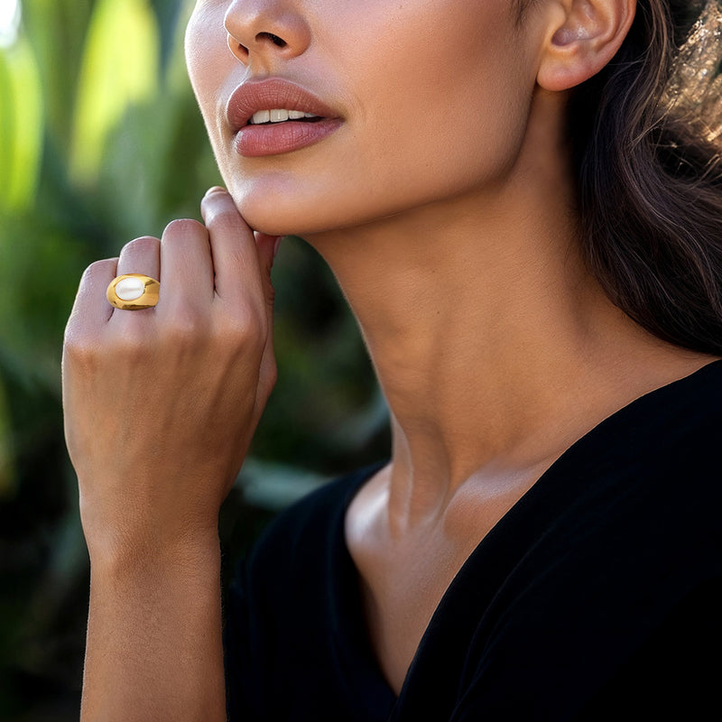 Gold oval pearl ring on finger, oval mother-of-pearl face