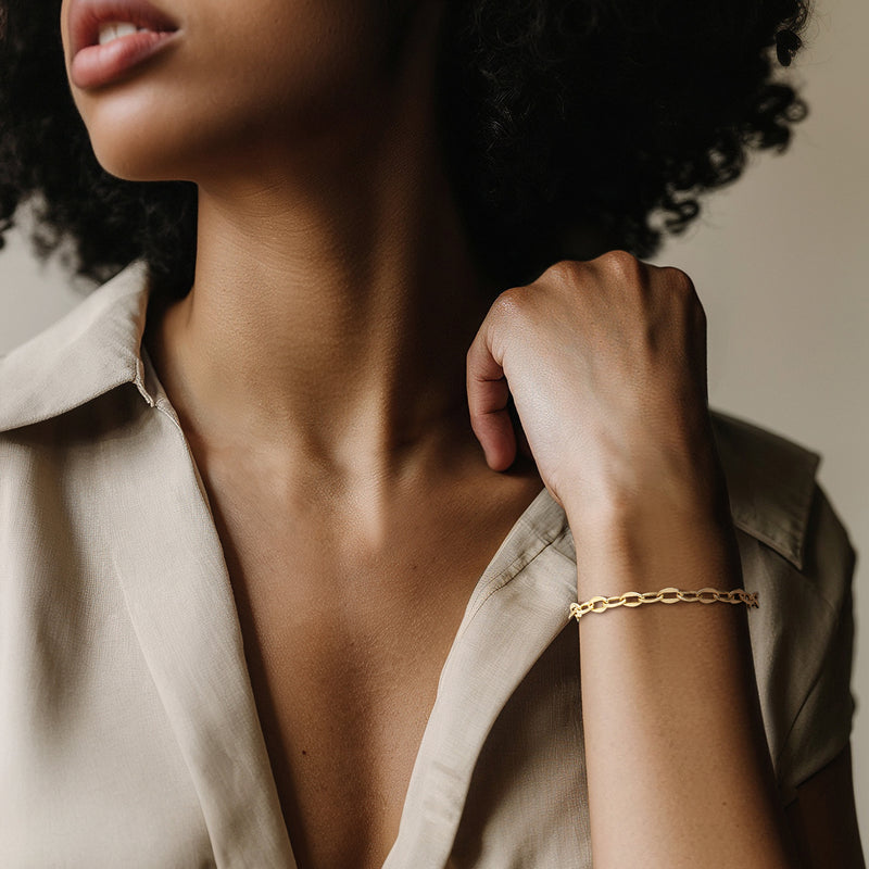 Yellow gold oval-link bracelet worn on wrist with polished chain links