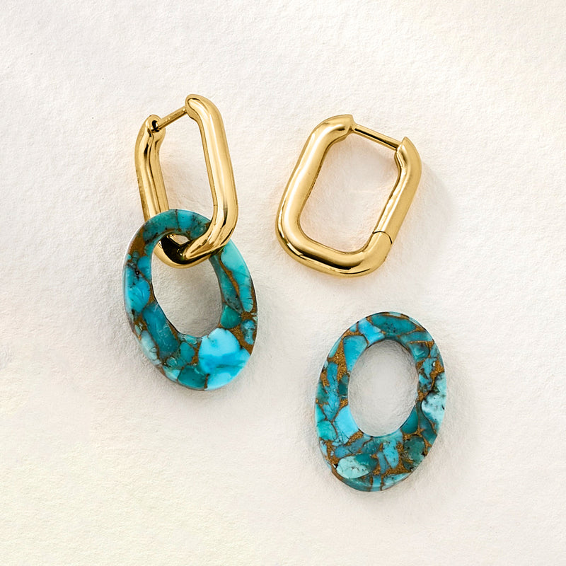 Gold hoop earrings with oval turquoise drops, laid out pair with teal stones