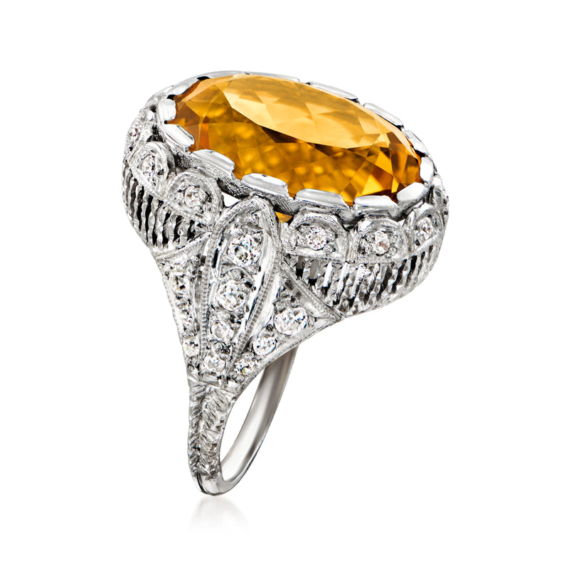 Platinum oval citrine ring with diamond accents, detailed side setting and prong border.