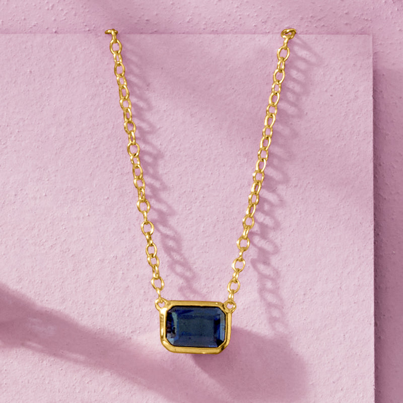 Gold sapphire necklace with blue square-cut pendant on chain, front view