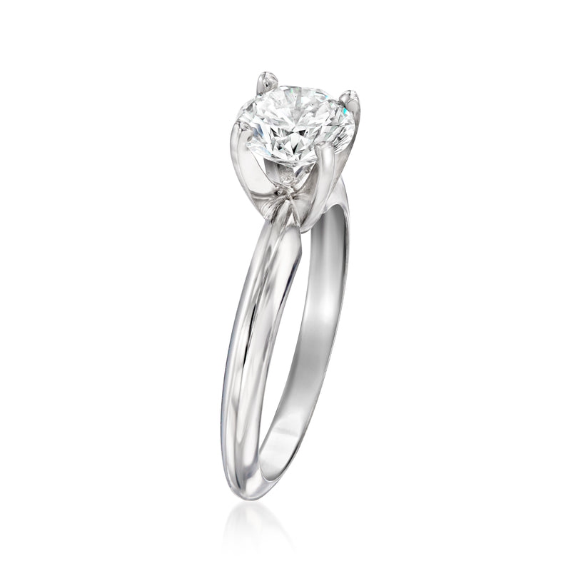 White gold solitaire diamond ring angled view, four-prong setting on polished band.